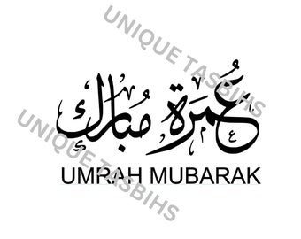 May include: Black and white calligraphy in Arabic script that reads "Umrah Mubarak".