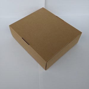 May include: A plain brown cardboard box with a square shape.