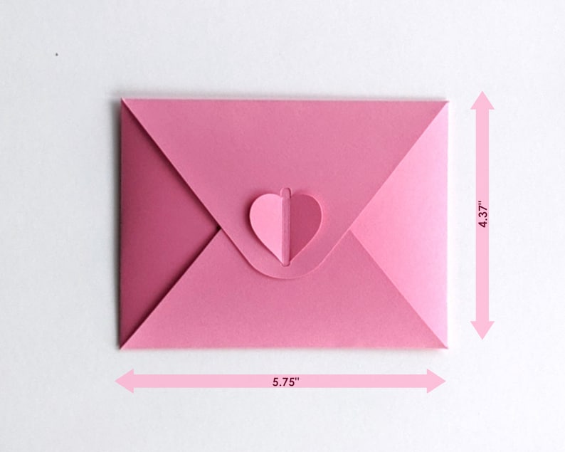 Op de afbeelding: Een roze papieren envelop met een hartvormige sluiting. De envelop is 14,6 cm breed en 11,1 cm hoog. De hartsluiting heeft een lichtere roze tint. De envelop is gesloten.