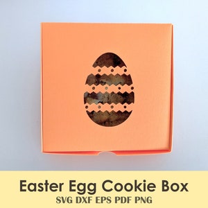 May include: A bright orange Easter egg cookie box with a cut-out design of an egg with a white and black patterned design. The box is ideal for holding cookies or other treats.