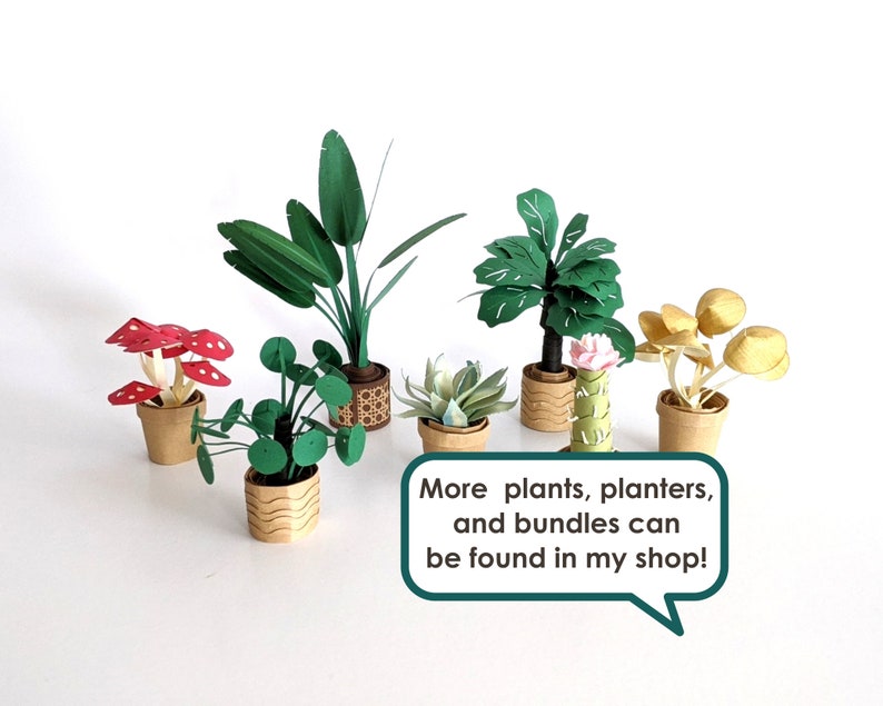 May include: A collection of papercraft plants in pots, including a red mushroom plant, a green leafy plant, a palm tree, a succulent, and a cactus. The text "More plants, planters, and bundles can be found in my shop!" is in a speech bubble.