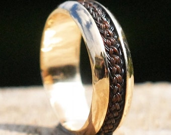 May include: A gold band ring with a brown braided leather inlay.