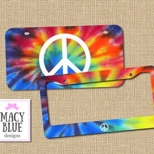 May include: A tie-dye license plate frame with a peace sign in the center. The frame is blue, green, yellow, orange, and red.