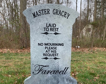 May include: A grey stone tombstone with the inscription "Master Gracey Laid to Rest No Mourning Please At His Request. Farewell" in black lettering.