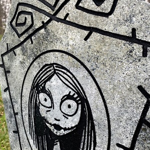 May include: A black and white illustration of a character from the film The Nightmare Before Christmas. The character is a woman with long black hair, large eyes, and a stitched mouth. The illustration is on a grey, textured background.