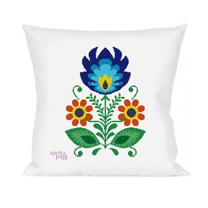May include: White square pillow featuring a colorful floral design. The design includes a large blue flower at the top, two orange flowers with yellow centers, green leaves, and a central stem. The pillow has the text "Igielka MB" in the bottom left corner.