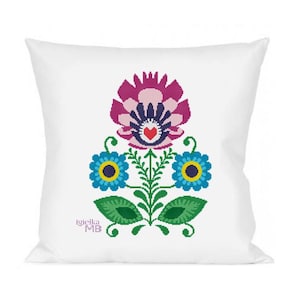 May include: White square pillow featuring a floral design in shades of purple, blue, green, and yellow. The design includes a large central flower, two smaller flowers, and stylized leaves. The text "Igielka MB" is in the lower left corner.