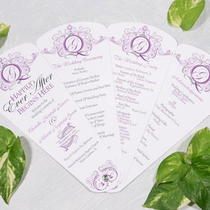 May include: Purple and white wedding program fan with a decorative design. The program includes the wedding ceremony, wedding party, and acknowledgements. The text reads "Happily Ever After Begins Here".