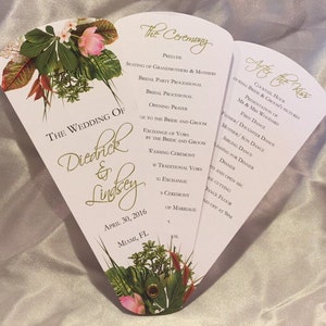 Op de afbeelding: Een witte bruiloftprogramma-waaier met een bloemenontwerp. De voorkant toont de tekst "The Wedding of Diedrick & Lindsey" met de datum "April 30, 2016" en de locatie "Miami, FL". De achterkant geeft de volgorde van de gebeurtenissen voor de huwelijksceremonie en de receptie.