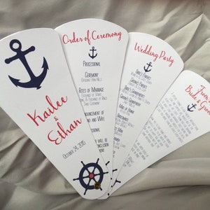 May include: Wedding ceremony program fans with a nautical theme. The fans feature an anchor, a ship's wheel, and the names Kailee & Ethan. The program includes the order of ceremony, wedding party, and a message from the bride and groom.