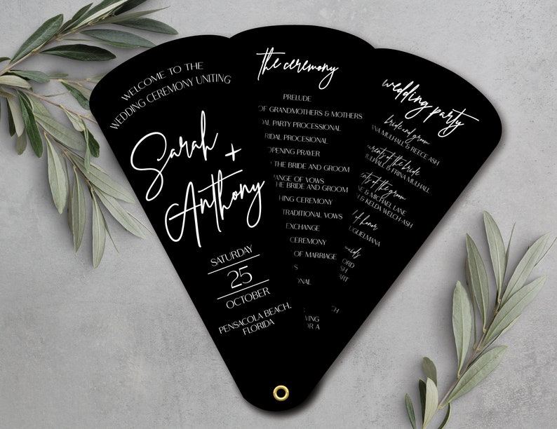 May include: Black wedding ceremony program fan with white text. The front side includes the couple's names, "Sarah + Anthony", the date "Saturday, 25 October", and the location "Pensacola Beach, Florida". The back side lists the wedding ceremony order and the wedding party.