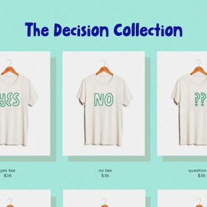 May include: Three white t-shirts with different slogans: "YES", "NO", and "??". The slogans are in green outlined text. The t-shirts are hanging on wooden hangers.