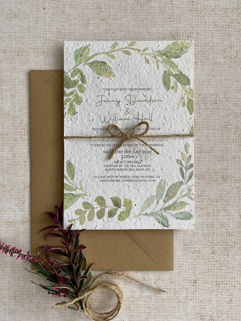 May include: A wedding invitation printed on plantable paper with a watercolor design of green leaves and branches. The invitation is tied with twine and includes the names Jenny Davidson and William Hall, the date Saturday, July 16th, 2022, and the time 1:00 PM. The invitation also includes the location Newton Hall, Newton by the Sea, Alnwick, Northumberland, NE66 3DZ. The RSVP information is JennyandWilliamwed@gmail.com.
