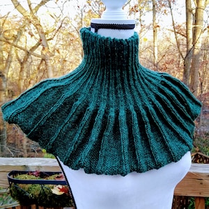Peut inclure: Un col roulé en tricot vert foncé avec un col haut et un bas large et plissé. Le col roulé est fait d'un fil doux et texturé et est parfait pour ajouter une touche de chaleur et de style à n'importe quelle tenue.