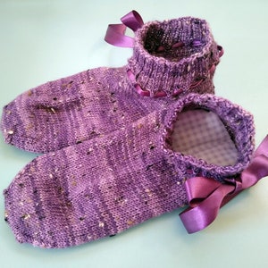 Pode incluir: Meias de lã roxas com um padrão salpicado e laços de fita de cetim. As meias têm um forro de vichy.