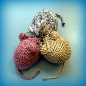 Puede incluir: Tres juguetes de ratón de punto en diferentes colores: rosa, marrón y beige. Los ratones están apilados uno encima del otro.