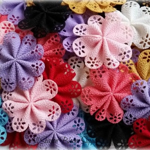 May include: A collection of 20 handmade fabric flowers in various colors, including pink, red, blue, purple, white, and yellow. Each flower has a scalloped edge and a delicate lace design.