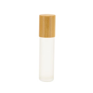 May include: A clear glass roller bottle with a natural wood cap. The bottle is frosted and has a simple design.