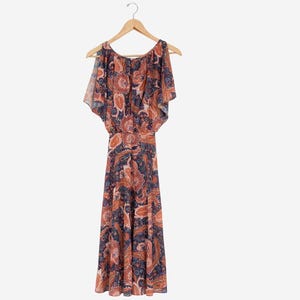 May include: A flowing, paisley-print dress in shades of rust, navy, and blush pink, hanging on a wooden hanger. The dress features a round neckline, flutter sleeves, and a gathered waist. The dress is approximately 55 inches long.