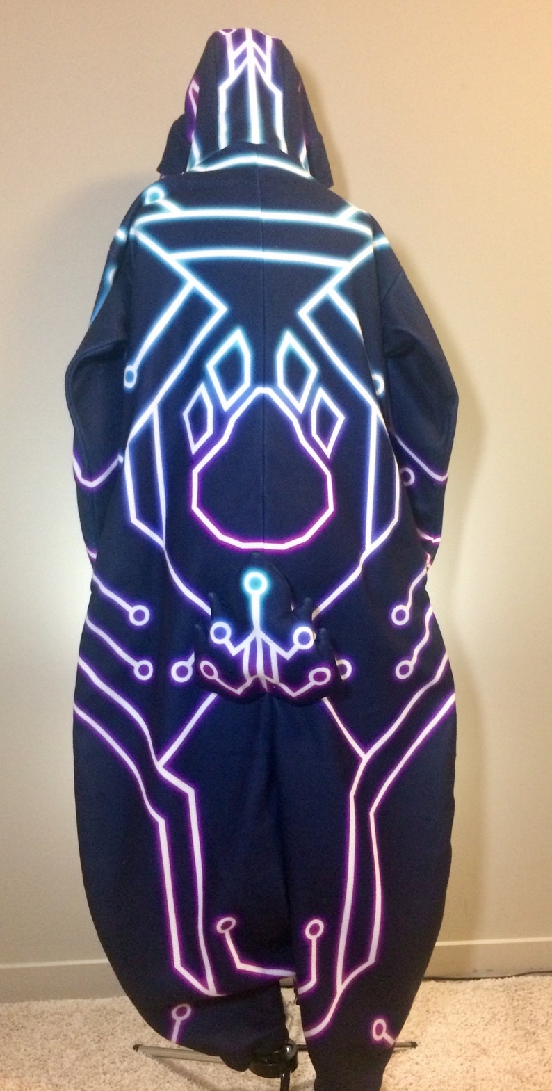 May include: A black hooded sweatshirt with a neon pink, blue, and white circuit board design. The design features a paw print in the centre.