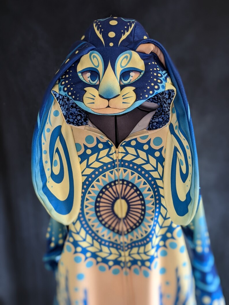 May include: A blue and yellow hooded sweatshirt with a mandala pattern and a matching blue and yellow cat face hood.