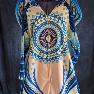 May include: A blue and yellow patterned hooded jumpsuit with a bunny head design. The hood has a zipper closure and the jumpsuit has a full-length zipper.
