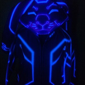 May include: A blue glow-in-the-dark hooded jacket with a geometric pattern. The hood has a bunny face design.
