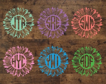 Puede incluir: Seis diseños de girasol de diferentes colores con un monograma en el centro de cada uno. Los monogramas son JTR, SRE, SWM, HYC, YWD y AOF. Los girasoles tienen un estilo similar con un círculo en el centro y pétalos que irradian hacia afuera.