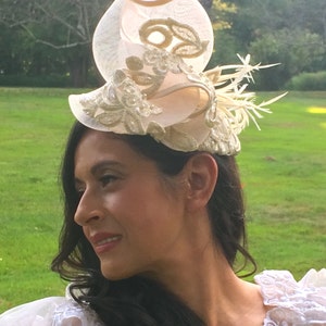 Ivory Embroidered Lace Fascinator with Gold Metallic threads and Pearls. Embellished with Feathers and Silk Trimmed Crinoline.