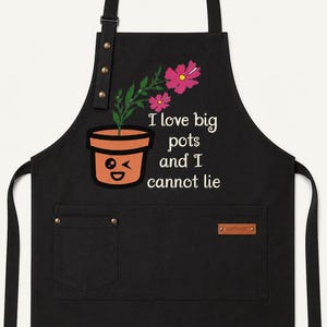 May include: A black apron featuring a graphic of a winking terracotta flower pot with pink flowers and the text "I love big pots and I cannot lie". The apron includes a neck strap with metal hardware and two front pockets with a small brown label.