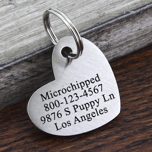 May include: Silver heart-shaped pet ID tag with engraved text: "Microchipped 800-123-4567 9876 S Puppy Ln Los Angeles"