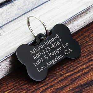 May include: Black bone-shaped dog tag with engraved text: "Microchipped 800-123-4567 1001 S Puppy Ln Los Angeles, CA"