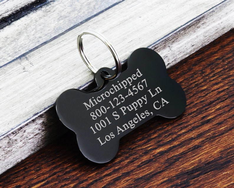 May include: Black bone-shaped dog tag with engraved text: "Microchipped 800-123-4567 1001 S Puppy Ln Los Angeles, CA"