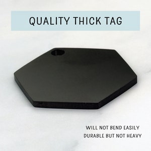 May include: Black hexagonal tag with a hole in the top. The tag is thick and durable, but not heavy.  "QUALITY THICK TAG" is printed in white on the top of the tag.  "WILL NOT BEND EASILY DURABLE BUT NOT HEAVY" is printed in black at the bottom of the tag.