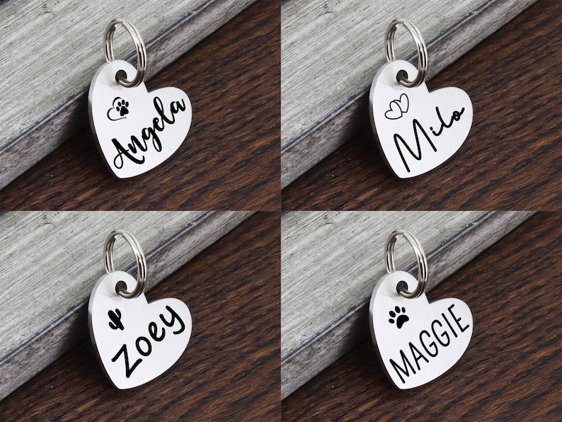May include: Four silver heart-shaped dog tags with key rings. The tags are engraved with the names "Angela", "Milo", "Zoey", and "Maggie" and have paw print or heart designs.