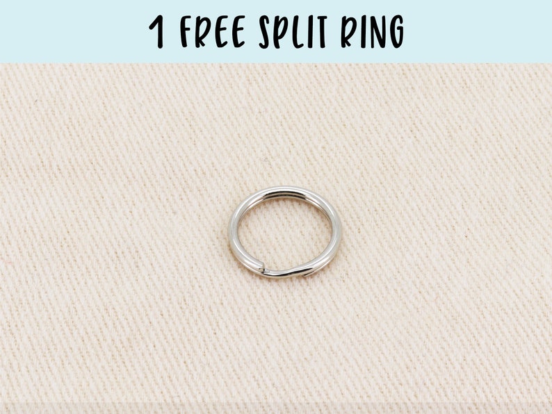 May include: A silver split ring, a metal ring that opens and closes, on a beige fabric background. 1 FREE SPLIT RING is written in black text at the top of the image.
