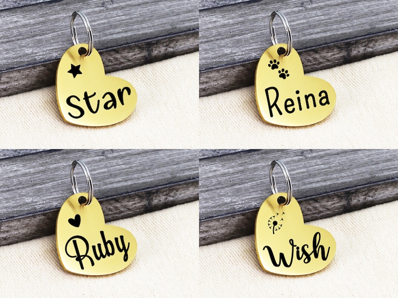 May include: Four gold heart-shaped pet ID tags with different designs and names. The tags feature a star, paw prints, a heart, and a dandelion. The names on the tags are Star, Reina, Ruby, and Wish.