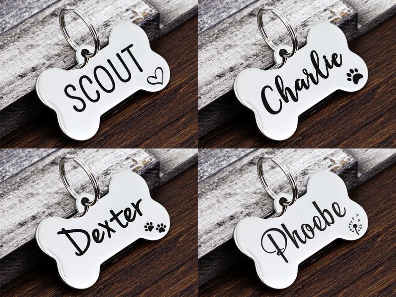 May include: Four silver bone-shaped dog tags with engraved names: Scout, Charlie, Dexter, and Phoebe. Each tag has a small design, such as a heart, paw print, or flower.