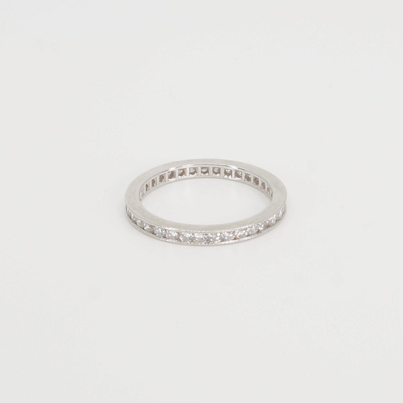 Op de afbeelding: Een zilveren bandring met een rij kleine diamanten die in de band zijn gezet.
