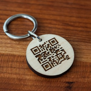 May include: A wooden keyring with a silver key ring and a laser-engraved QR code.