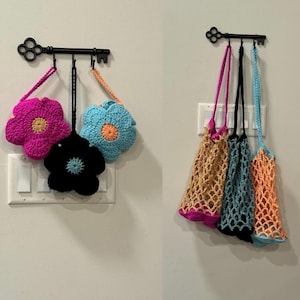 Könnte beinhalten: Drei gehäkelte Blumen-Taschen, die an einem schlüsselförmigen Haken hängen, und drei gehäkelte Netztaschen, die an einem schlüsselförmigen Haken hängen.