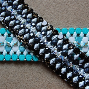 May include: Two beaded bracelets, one black and white with a geometric pattern and the other turquoise and white with a hexagonal pattern.