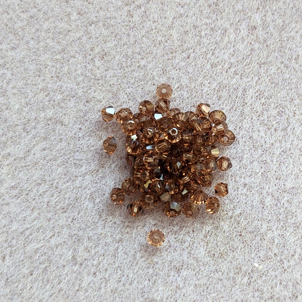 SWAROVSKI BICONE CRYSTALS, 2.5 mm, Light Smoked Topaz, sold in units of 50 crystals.