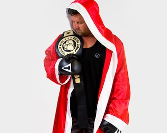 May include: A red satin boxing robe with white trim and a hood. The robe is worn by a person holding a black boxing glove and a gold boxing championship belt. The belt has the text "Boxing Champ" and "Danny Mitchell" on it.