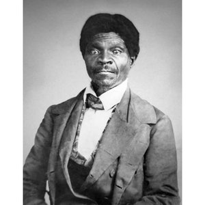 May include: Black and white portrait photograph of a man wearing a suit and bow tie.