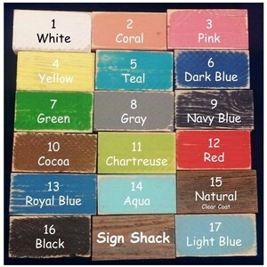 K&ouml;nnte beinhalten: Ein Raster aus siebzehn rechteckigen Holzbl&ouml;cken, die jeweils eine einzigartige Lackfarbe und eine entsprechende Nummer von 1 bis 17 aufweisen. Die Farben umfassen Wei&szlig;, Koralle, Pink, Gelb, T&uuml;rkis, Dunkelblau, Gr&uuml;n, Grau, Marineblau, Kakao, Chartreuse, Rot, K&ouml;nigsblau, Aqua, Natur, Schwarz und Hellblau. Der Text Sign Shack ist auf Block 16 gedruckt.