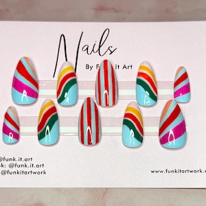 May include: A set of ten artificial nails with a light blue base and colorful striped designs in red, pink, yellow, and green. The word "Nails" is written at the top of the card.