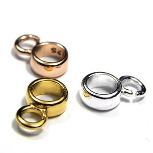 Puede incluir: Tres anillos de salto de metal en oro, plata y oro rosa. Cada anillo tiene un peque&ntilde;o bucle en un lado.