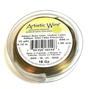 Könnte beinhalten: Eine Spule mit 18 Gauge antikem Messingdraht von Artistic Wire. Die Spule enthält 10 Yards (9,14 Meter) Draht mit einem Durchmesser von 0,040 Zoll (1,02 mm).