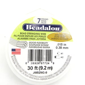 Pode incluir: Uma bobina de fio para enfiar contas Beadalon de 7 fios, cor ouro acetinado. O fio mede 30 pés (9,2 metros) de comprimento e tem um diâmetro de 0,015 polegadas (0,38 milímetros).